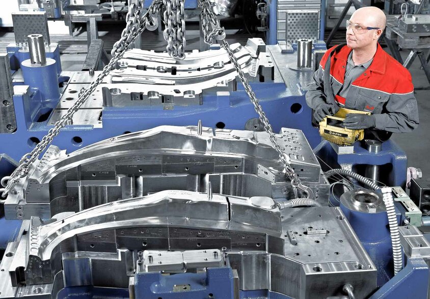 A tool manufacturing technician operates a crane system to assemble active components of a hot forming tool at weba Werkzeugbau, leader for toolmaking solutions in sophisticated quenching process. 