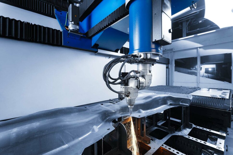 Precise laser cutting machine processing a component. The machine cuts through a complex-shaped metal part with high precision, generating sparks in the process. Modern laser cutting technology for the production of automotive components.