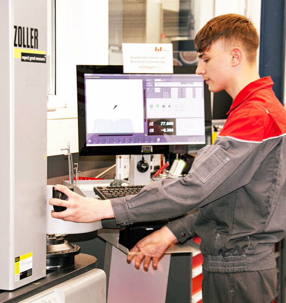 A metal technology apprentice concentrates on working on a technical system. Apprenticeship in Steyr at weba Werkzeugbau in metal technology at weba combines theoretical knowledge with practical experience on systems.